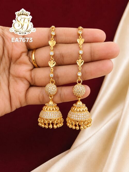 Premium gold finish long chain jhumka earrings with sparkling CZ stones, floral chain detailing, and traditional dome-shaped design for bridal and festive wear.