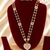 Premium gold finish heart pendant long haram with sparkling AD stones, ruby stone detailing, and heart link chain, perfect for bridal, wedding, and festive wear.
